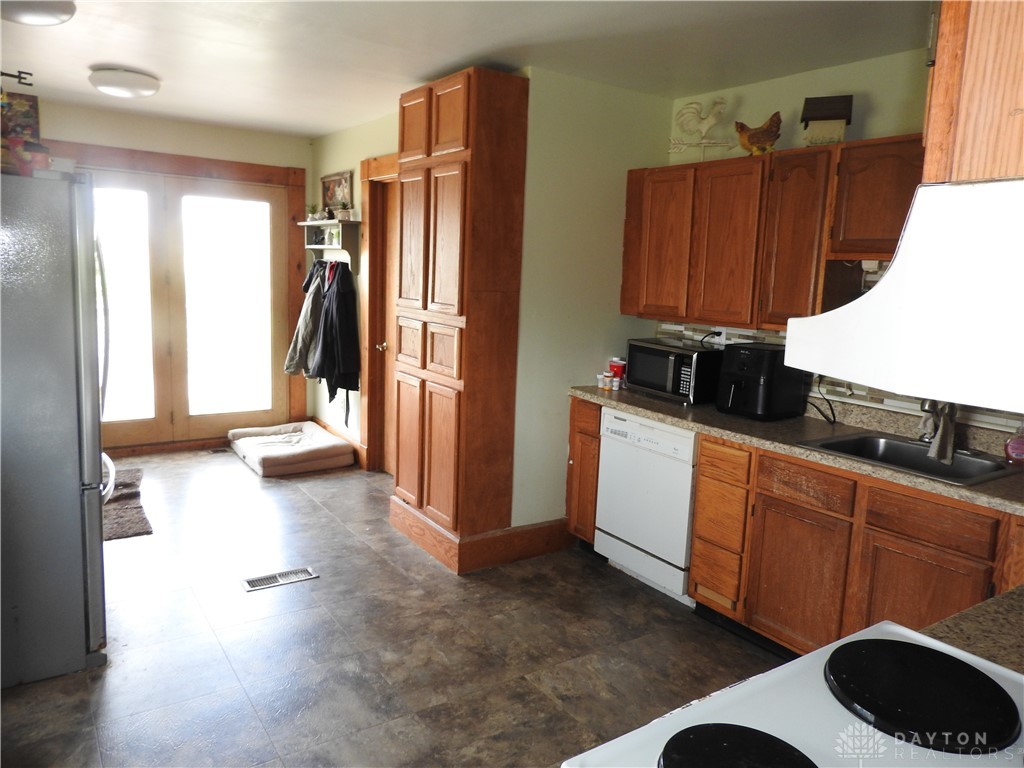 2105 East Loy Road Piqua, OH 45356 - Photo 12 of 26 This functional kitchen provides ample storage and natural light, perfect for culinary endeavors.