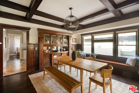 a dining room with wooden floor a chandelier and fireplace