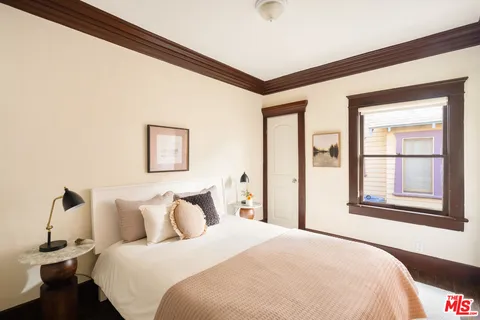 a bedroom with a bed and a large mirror