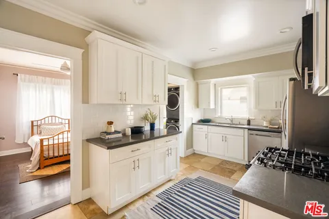 a kitchen with stainless steel appliances a sink a stove cabinets and a counter top space