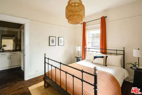 a bedroom with a bed and a painting on the wall