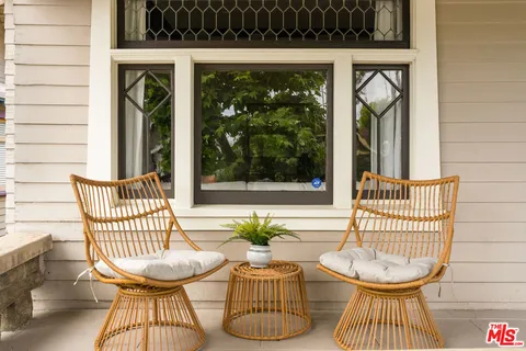 a view of a chairs and table in back yard of the house