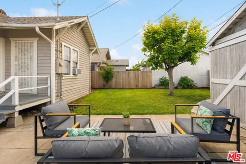 a backyard of a house with table and chairs