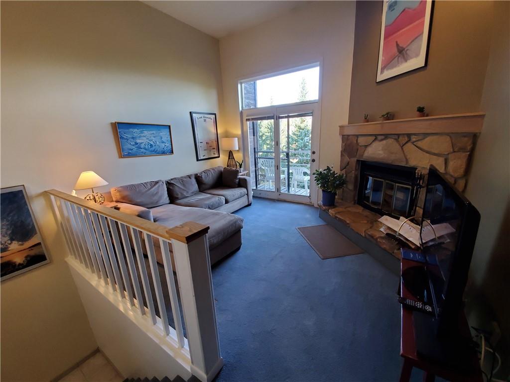 10000 Ryan Gulch Road, Unit 105 Wildernest, CO 80498 - Photo 2 of 24 a living room with furniture a fireplace and a large window