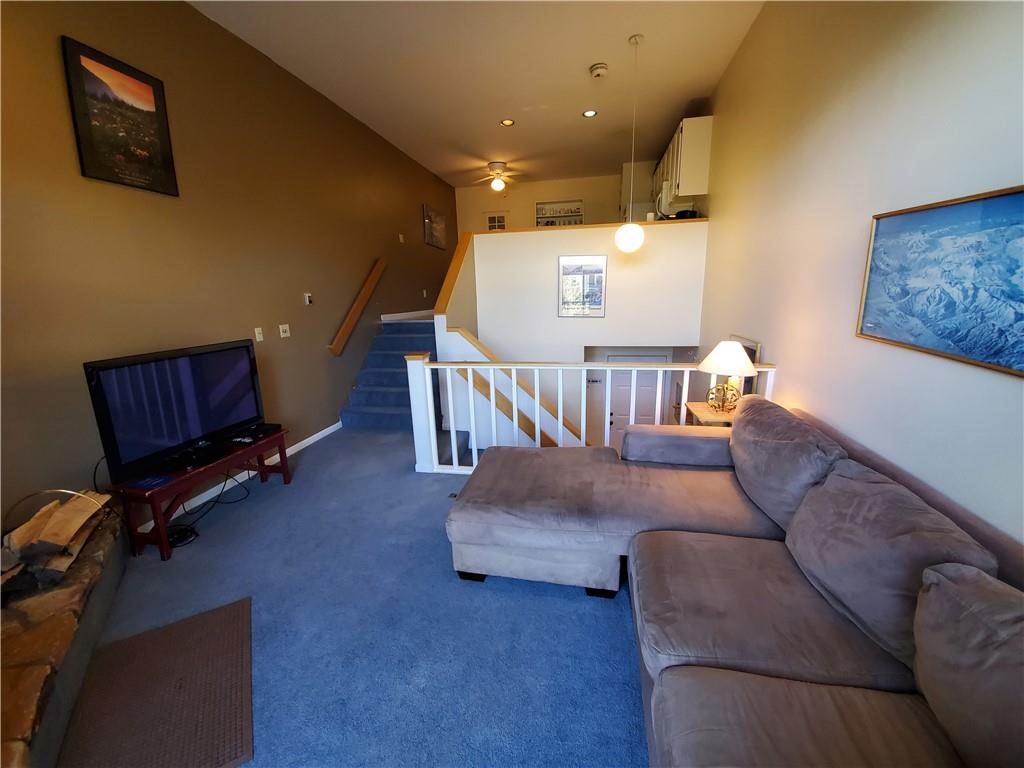 10000 Ryan Gulch Road, Unit 105 Wildernest, CO 80498 - Photo 3 of 24 a living room with furniture and a flat screen tv