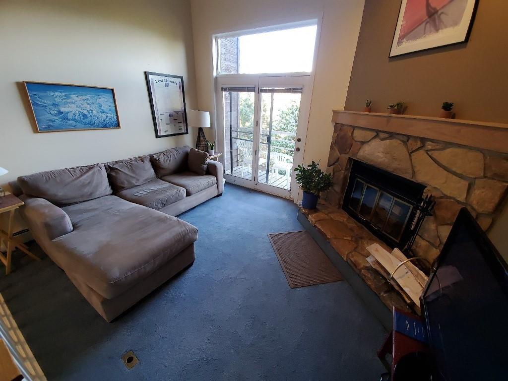 10000 Ryan Gulch Road, Unit 105 Wildernest, CO 80498 - Photo 4 of 24 a living room with furniture and a fireplace