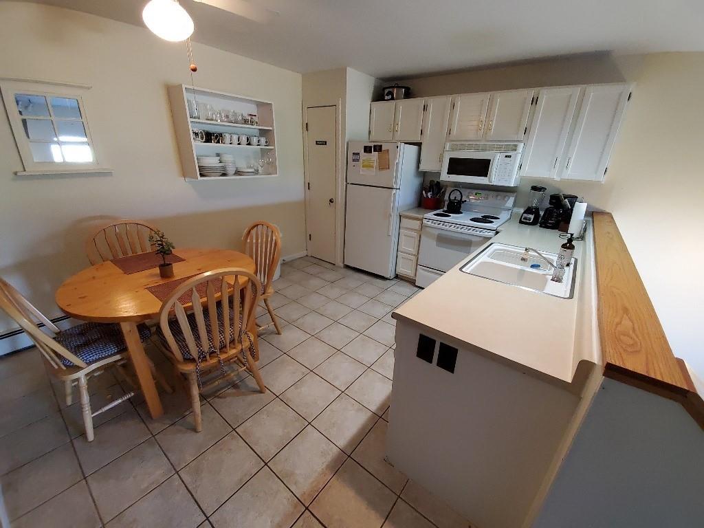 10000 Ryan Gulch Road, Unit 105 Wildernest, CO 80498 - Photo 7 of 24 a kitchen with stainless steel appliances a stove a sink a microwave a refrigerator a table and chairs