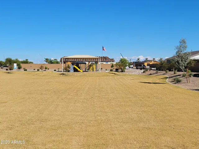 a view of a swimming pool with a lawn chairs under an umbrella