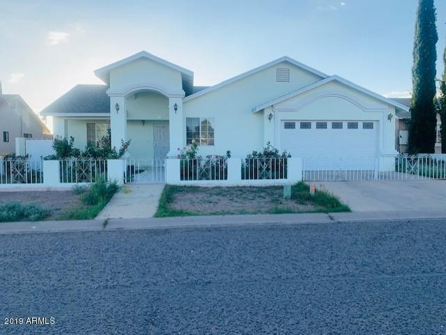 a view of a house with a yard and pathway