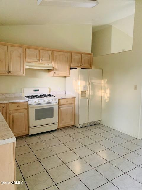 704 Elizabeth Avenue Douglas, AZ 85607 - Photo 3 of 10 a kitchen with a stove top oven cabinets and a refrigerator