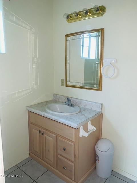 704 Elizabeth Avenue Douglas, AZ 85607 - Photo 6 of 10 a bathroom with a granite countertop toilet sink and mirror