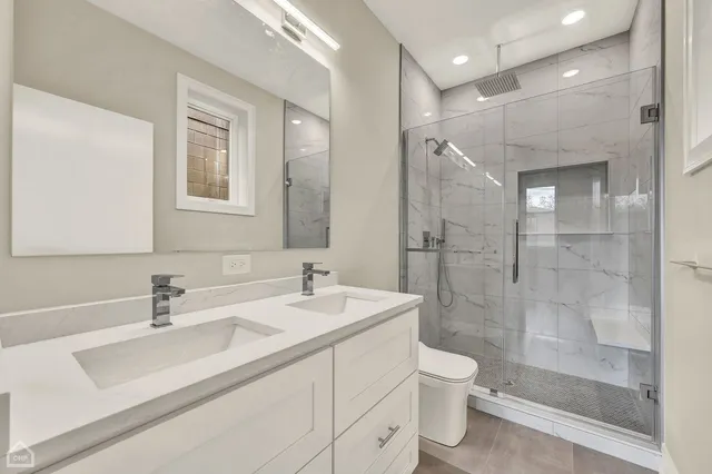 a bathroom with a sink a toilet and shower