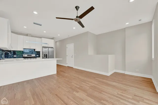 a view of kitchen with stainless steel appliances refrigerator stove microwave and cabinets