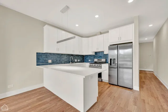 a kitchen with stainless steel appliances a refrigerator and a stove top oven
