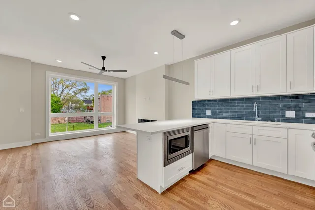 a view of a kitchen with wooden floor and stainless steel appliances