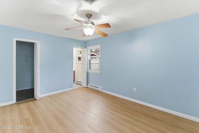 wooden floor in an empty room with a fan