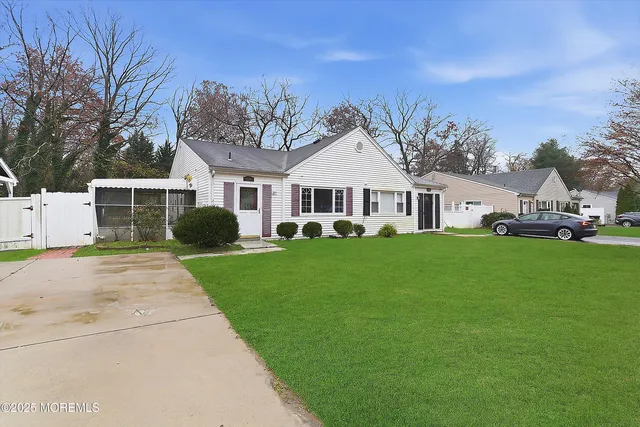 a front view of a house with a garden and trees