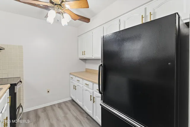 a kitchen with stainless steel appliances a refrigerator and a chandelier