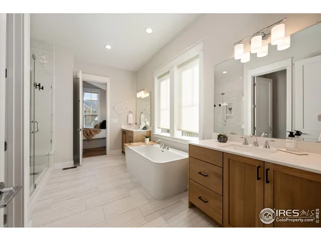 a bathroom with a double vanity sink mirror and bathtub