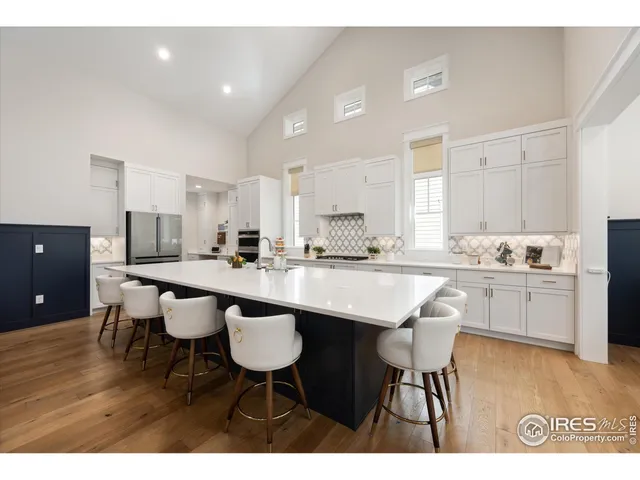 a kitchen with a dining table chairs and white stainless steel appliances