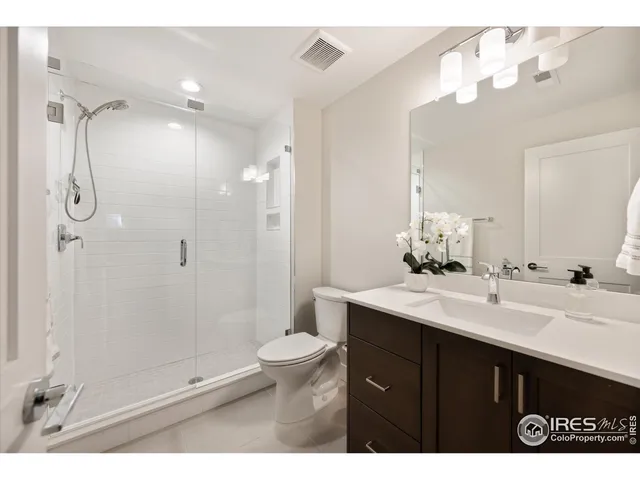 a bathroom with a sink vanity granite shower and a mirror
