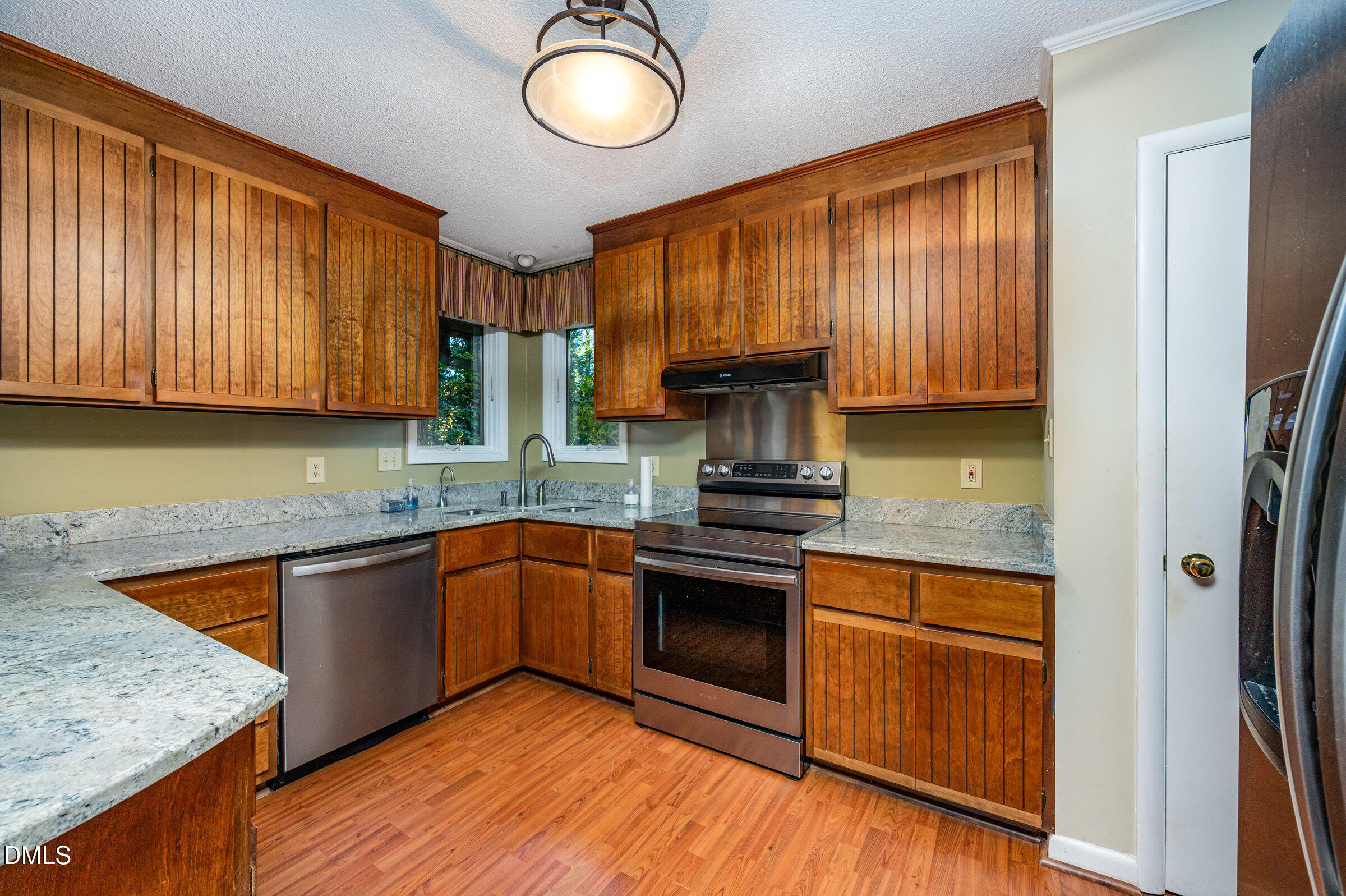 2900 Sylvania Drive Raleigh, NC 27607 - Photo 16 of 36 a kitchen with stainless steel appliances granite countertop wooden cabinets a sink and a stove