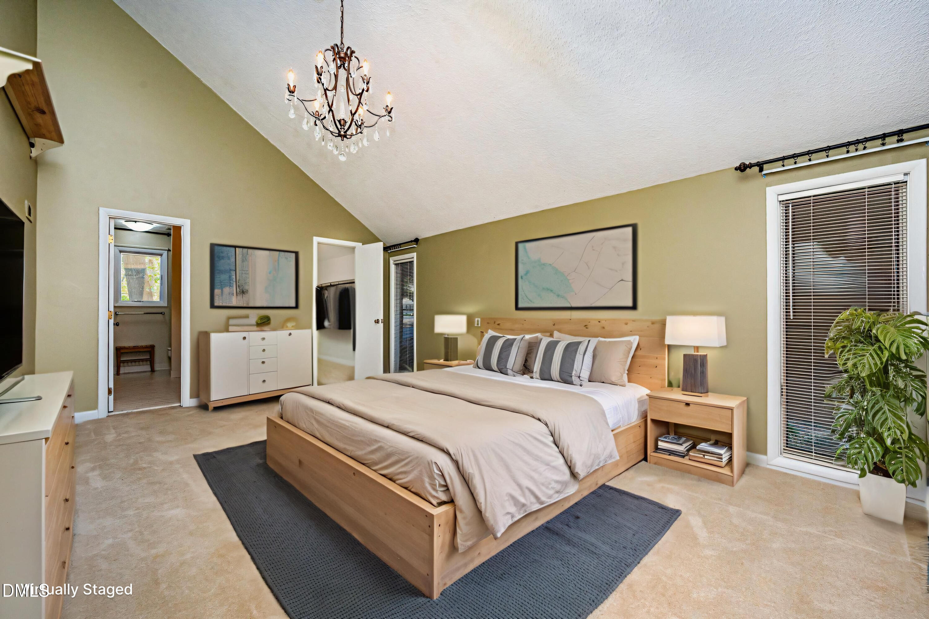 2900 Sylvania Drive Raleigh, NC 27607 - Photo 23 of 36 a spacious bedroom with a large bed a chandelier and windows