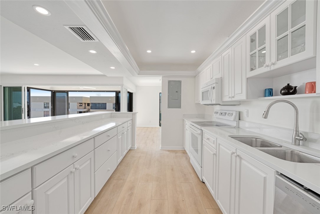 Undisclosed Address Sanibel, FL 33957 - Photo 15 of 30 a large white kitchen with a large window and stainless steel appliances