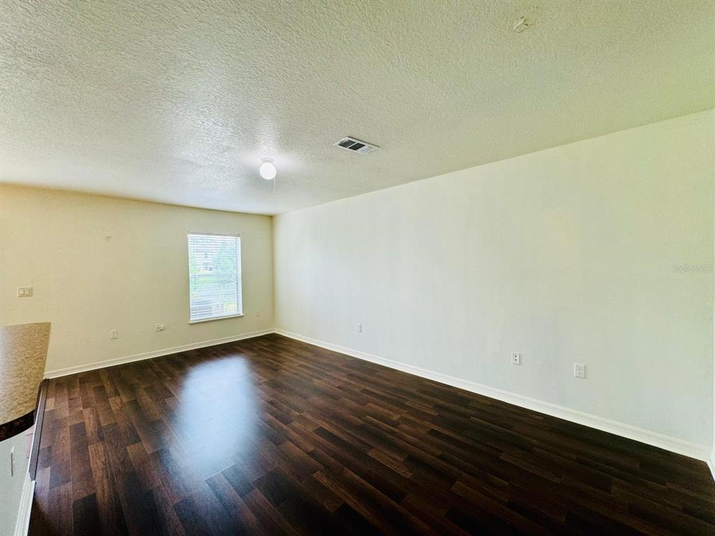 4518 Ashburn Square Drive Tampa, FL 33610 - Photo 28 of 34 a view of an empty room with wooden floor and a window
