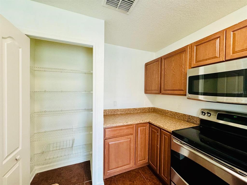 4518 Ashburn Square Drive Tampa, FL 33610 - Photo 6 of 34 a kitchen with stainless steel appliances a stove microwave and sink