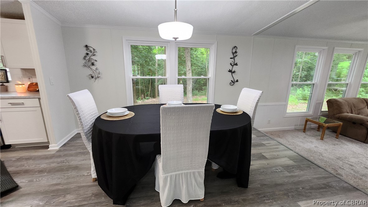 8065 Filly Run Road Gloucester, VA 23061 - Photo 4 of 33 Dining space featuring crown molding, a textured ceiling, and dark hardwood / wood-style floors