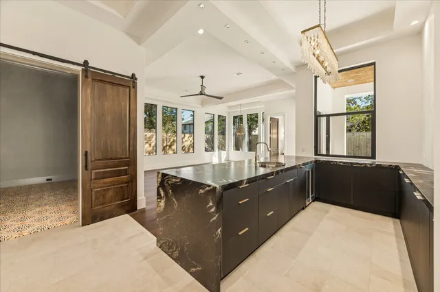 a kitchen with granite countertop a refrigerator and a sink