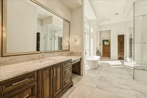 a spacious bathroom with a granite countertop sink a toilet and a shower