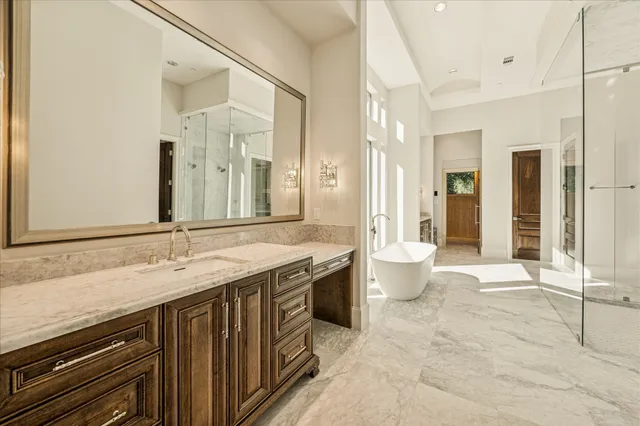 a spacious bathroom with a granite countertop sink a toilet and a shower