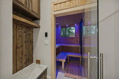 an empty room with wooden floor a ceiling fan and windows