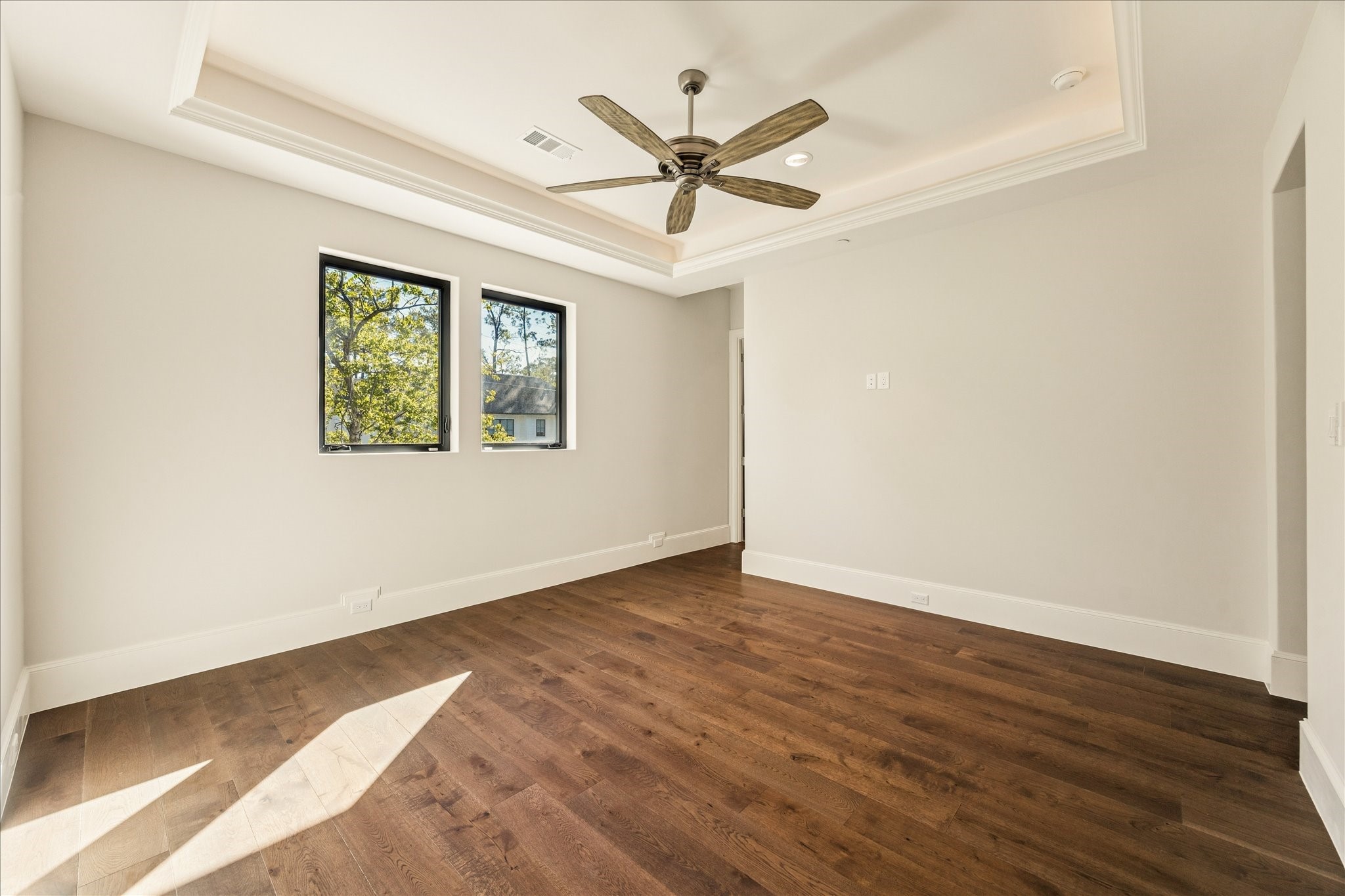 318 Knipp Road Houston, TX 77024 - Photo 29 of 44 an empty room with wooden floor ceiling fan and windows