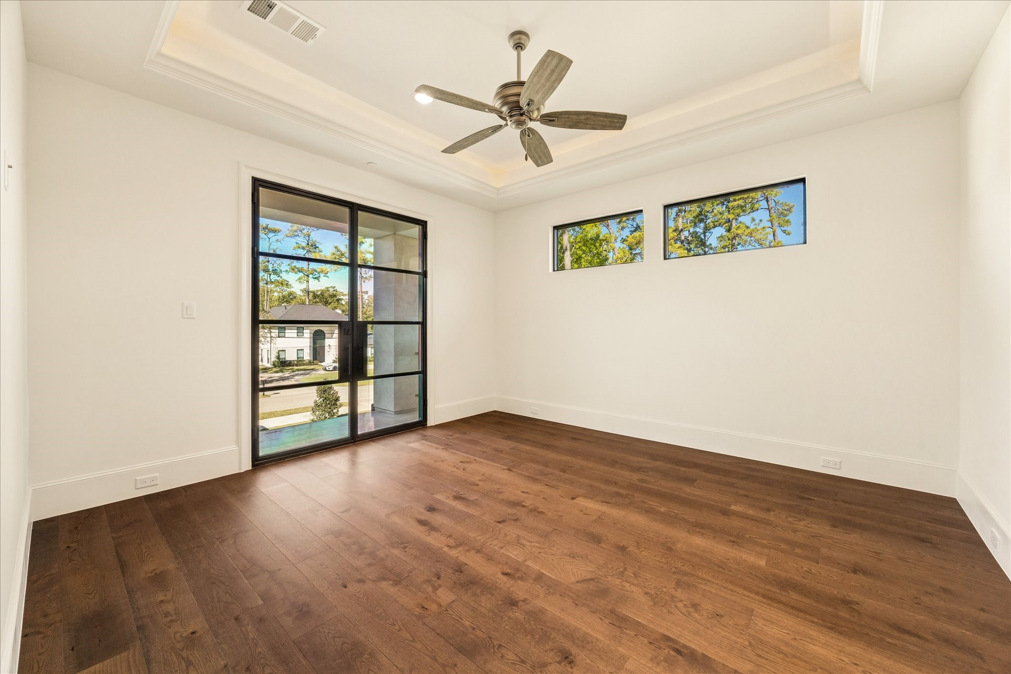 318 Knipp Road Houston, TX 77024 - Photo 30 of 44 an empty room with wooden floor chandelier fan and windows