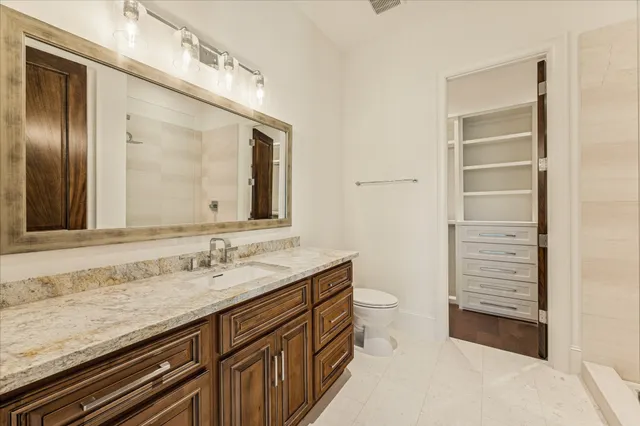 a bathroom with a granite countertop sink and a mirror