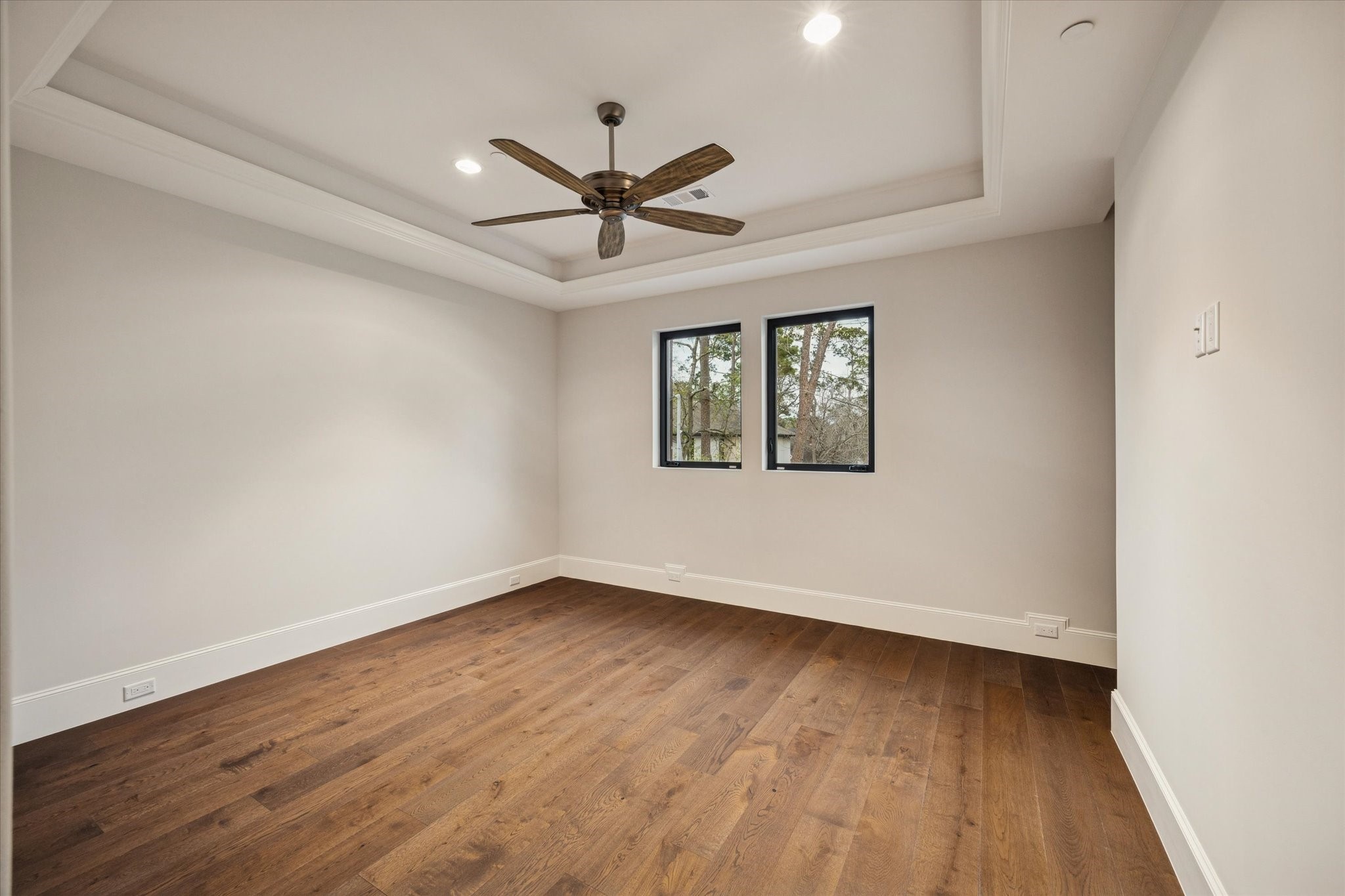 318 Knipp Road Houston, TX 77024 - Photo 32 of 48 an empty room with wooden floor a ceiling fan and windows