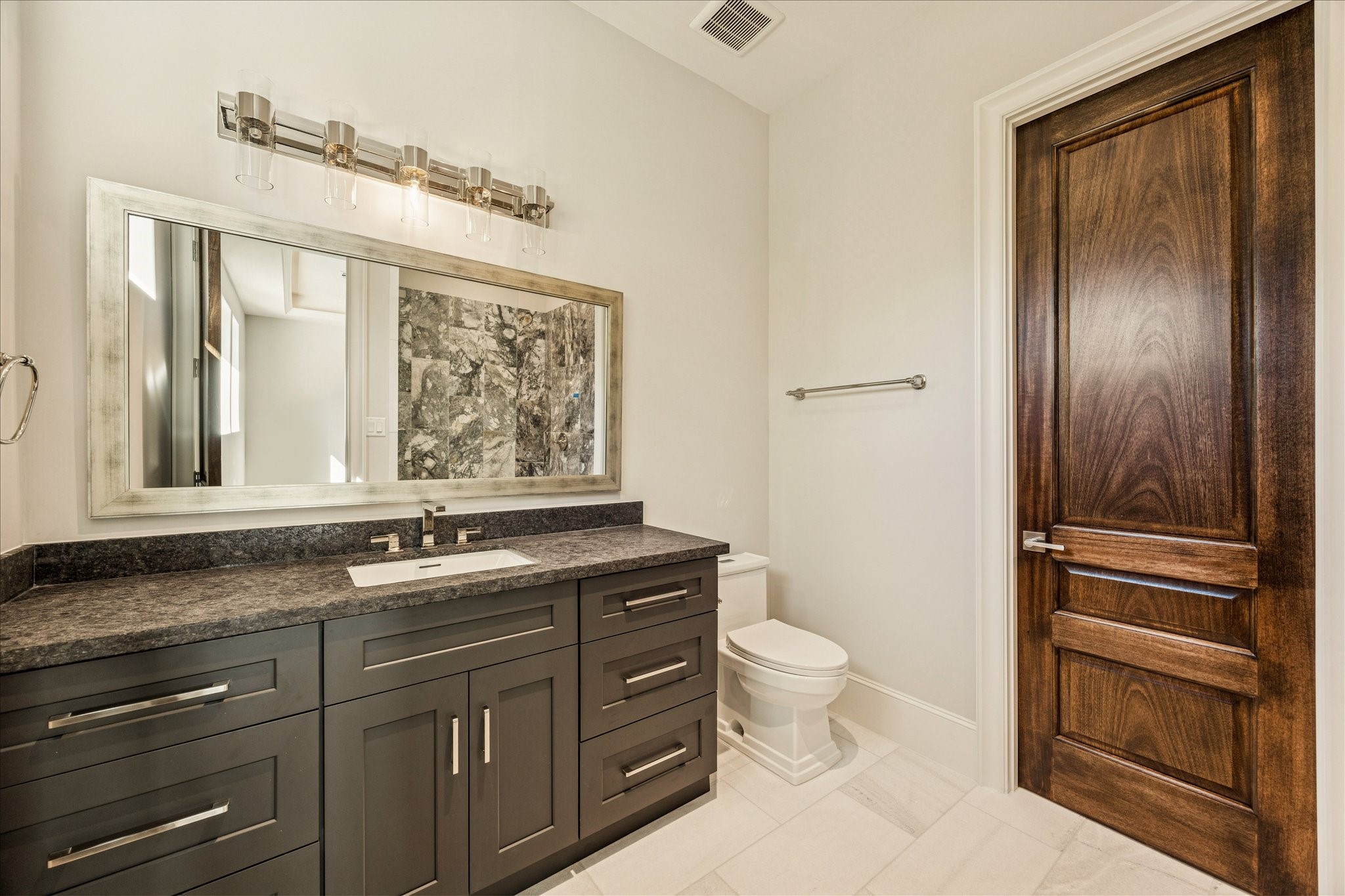 318 Knipp Road Houston, TX 77024 - Photo 33 of 44 a bathroom with a granite countertop toilet sink and mirror