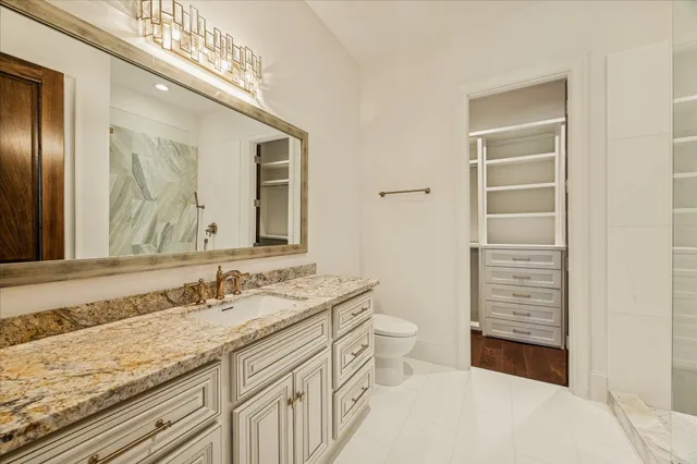 a bathroom with a sink a toilet and a mirror