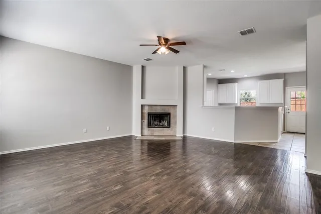 a view of a kitchen with wooden floor and a ceiling fan