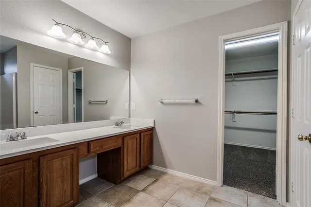 a spacious bathroom with a double vanity sink and a mirror