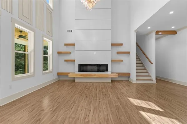 a living room with fireplace furniture and a large window