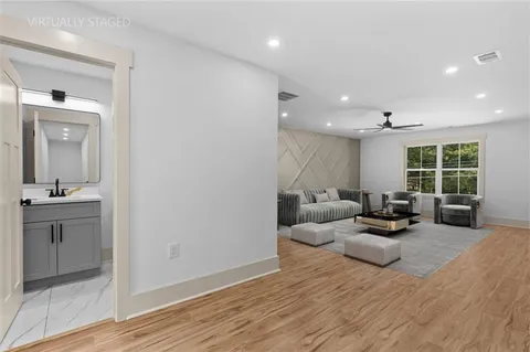 a view of empty room with wooden floor and fan