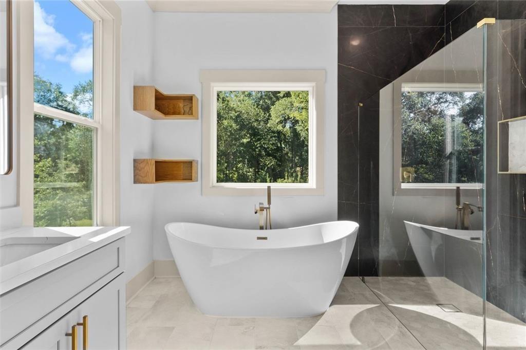 1960 Lost Mountain Road Powder Springs, GA 30127 - Photo 38 of 56 a white bath tub sitting in a bathroom next to a window
