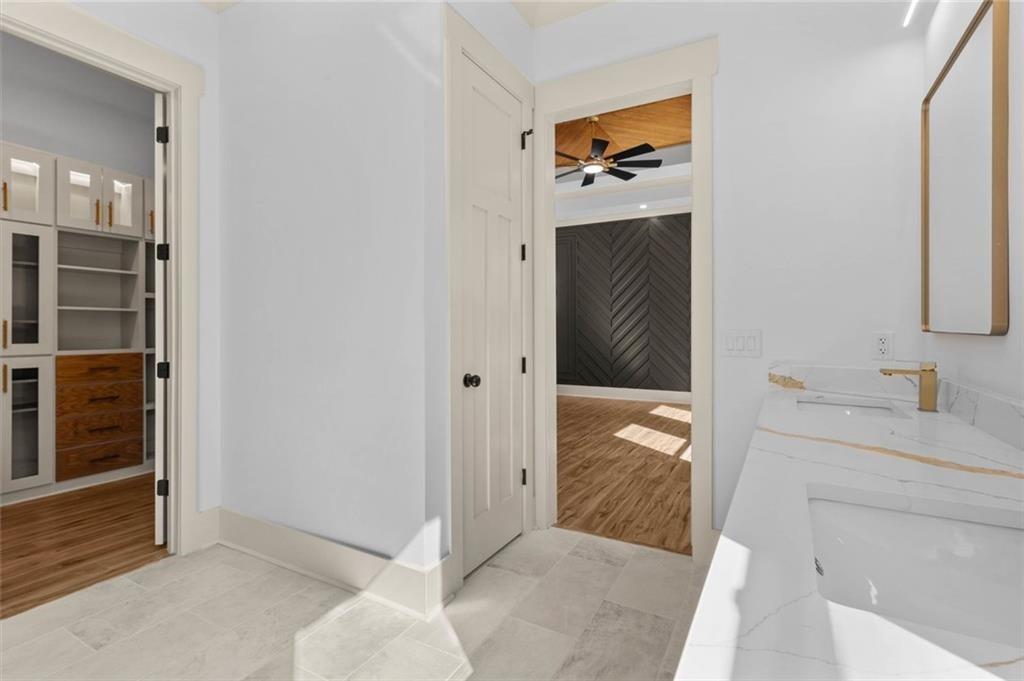 1960 Lost Mountain Road Powder Springs, GA 30127 - Photo 40 of 56 a en suite bathroom with a granite countertop sink and a mirror