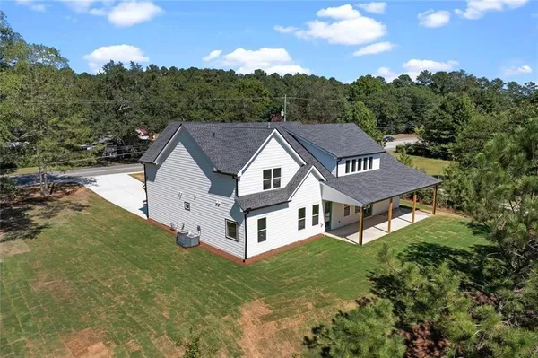 an aerial view of residential houses with outdoor space and trees