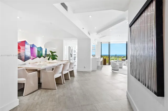 a view of a kitchen with kitchen island stainless steel appliances wooden floor dining table and chairs