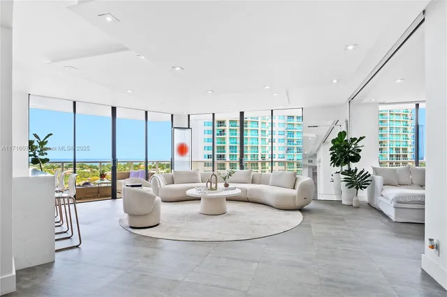 a living room with furniture and large windows
